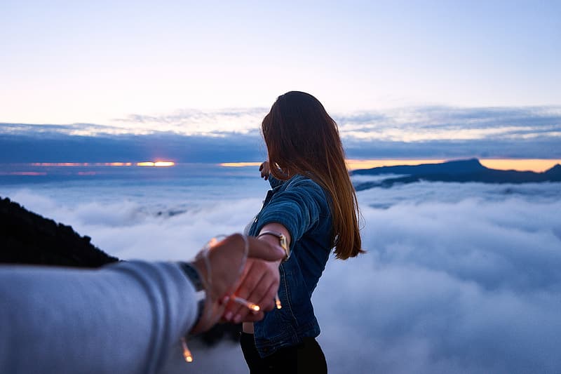 man-holding-woman-s-hand-on-top-of-mountain